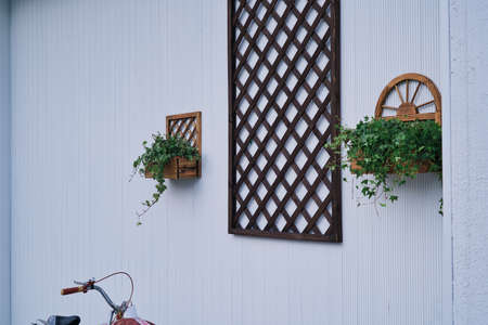 Window with wooden shutters and flowers on the wall of the houseの写真素材