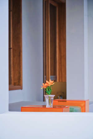 Orange vase with flowers on the terrace of the house.の写真素材