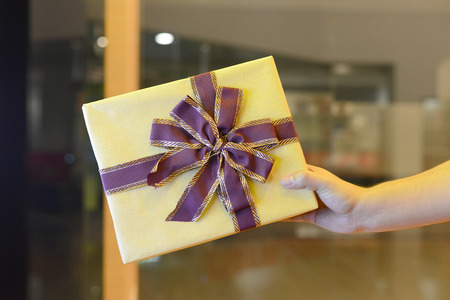Man holding a gift box in the hand for giving.の写真素材