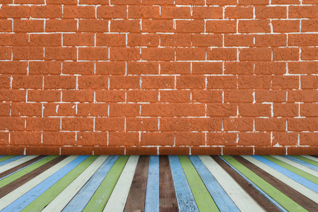Brick wall background with colorful wood floor.の写真素材