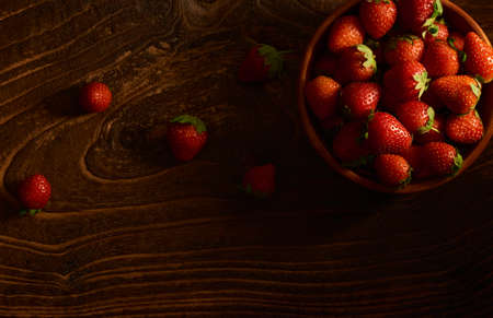 strawberries with strawberry leaf on a Wooden bowl on wooden board.の写真素材
