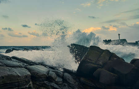 Sea wave with orange sunset sky in Pacific Ocean.
