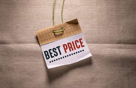 Best price - text on paper tag on linen background. Business conceptの写真素材