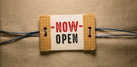 On a light background, a piece of paper with the text NOW OPEN. Business conceptの写真素材
