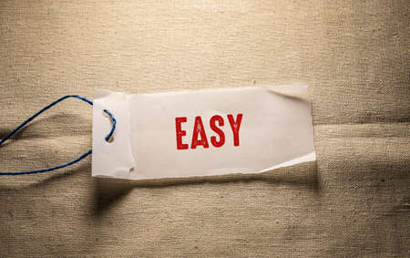 EASY text on torn paper on burlap background. Business conceptの写真素材