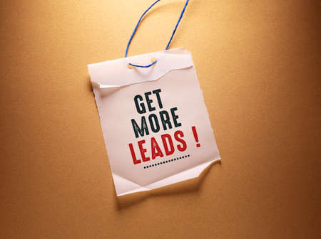 Get More Leads, words on torn paper on a brown background