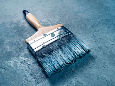 Close up of paint brush on textured wall