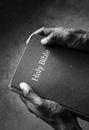 Close up of a old Holy Bible on human handの写真素材