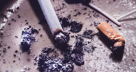 Closeup of discarded cigarette butts with ashの写真素材
