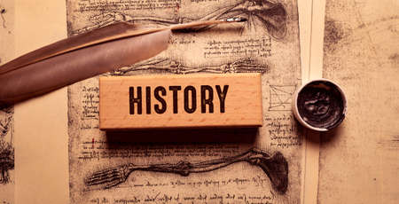 The word HISTORY is written on wooden blocks on an old book background.の写真素材