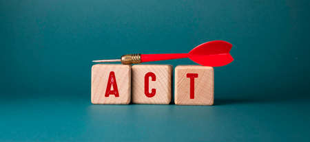 The word Act is written on wooden cubes with a red dart.の写真素材