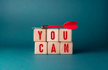 The concept of success. On a green background, a dart and cubes with the inscription.の写真素材