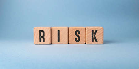 Risk word on wooden cubes on a blue background. Business conceptの写真素材
