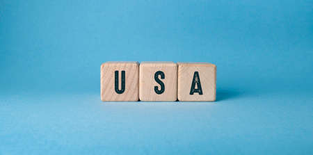 The word USA is written on wooden cubes on a blue background.の写真素材