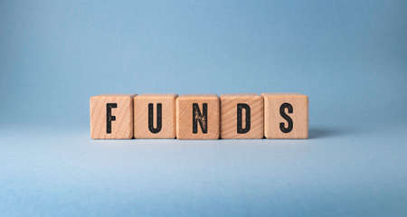 FUNDS word on wooden cubes on a blue background. Business concept.の写真素材