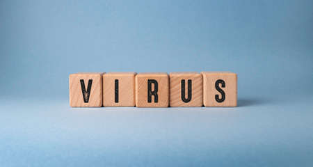 VIRUS word on wooden cubes on blue background. Business concept.