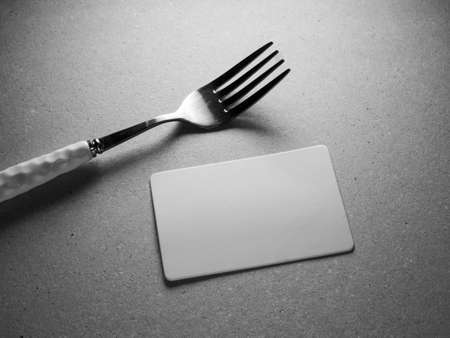 Blank business card and fork on table, black and white toneの写真素材