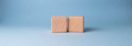 Two wooden cubes on a blue background. 3d rendering, 3d illustration.の写真素材