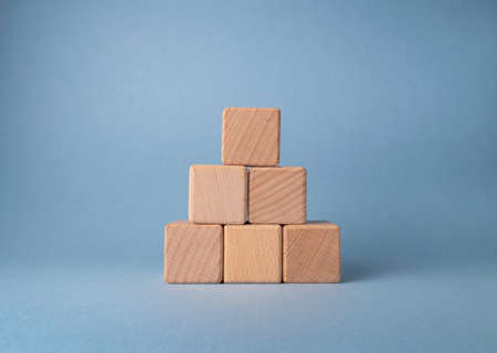Wooden blocks on a blue background. The concept of the development and growth of business.の写真素材