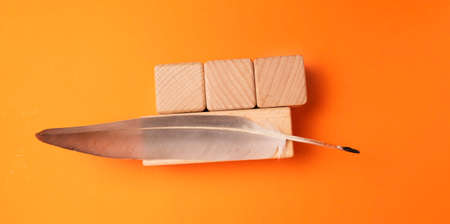 Quill and wooden cubes on an orange background. Place for text.の写真素材