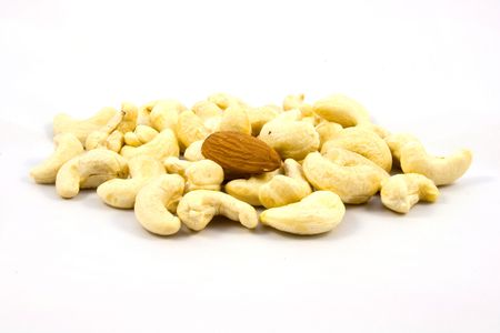 Cashew nuts and one almond isolated on white backgroundの写真素材