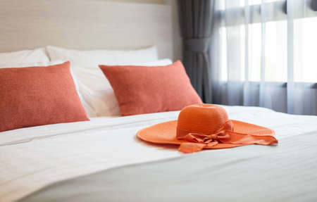 Orange pillows on the bed with hatの写真素材