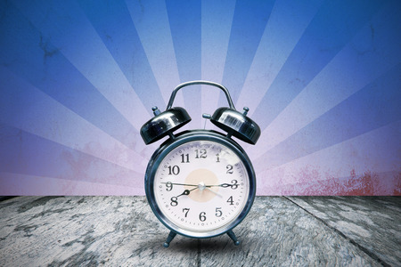 Retro alarm clock and grunge sun sunburst background