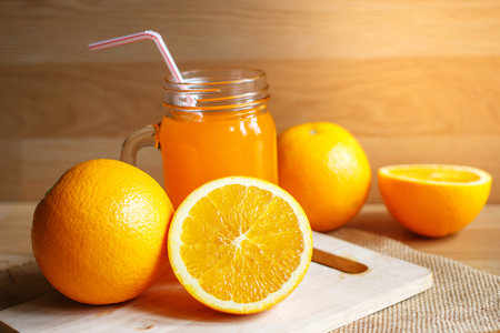 Orange and orange juice on wooden backgroundの写真素材