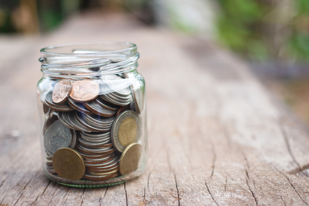 Money in the glass on wood table. Money Saving conceptの写真素材
