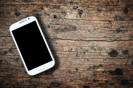 Smartphone on old wooden table backgroundの写真素材