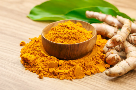 Turmeric powder in wooden bowls on wooden table