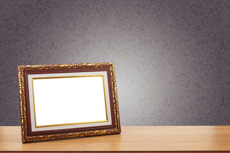 Photo frame on wooden table over grunge wall backgroundの写真素材