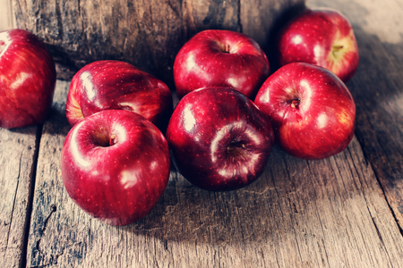Red apples on old wooden tableの写真素材