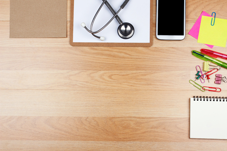 Office supplies and stethoscope on wooden table with copy space, top viewの写真素材