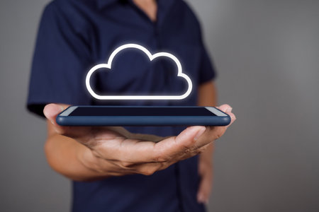 Man holding smartphone with icon cloud computer network and icon connection data information in hand.の写真素材