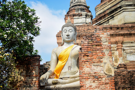 Stone buddha image blanket yellow robe in arcade at temple, ayutthaya, thailandの写真素材