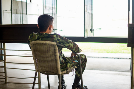 Former soldier sitting and showing his backの写真素材