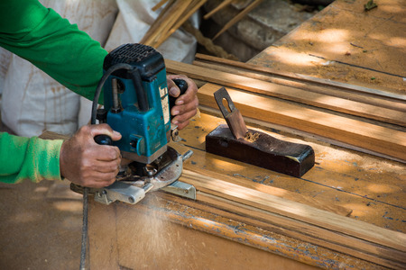 Hands of a carpenter planed wood