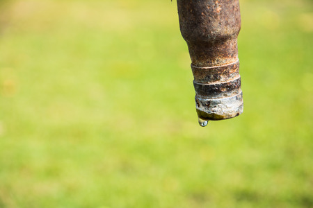 Water droplets at faucetの写真素材
