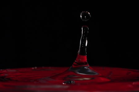 Water drop in red backgroundの写真素材