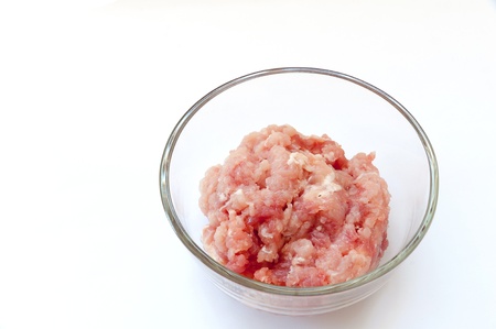 raw minced pork in a clear bowl, isolated on white backgroundの写真素材