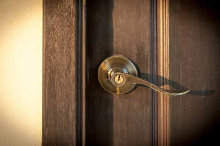 antique brass lever handle on wooden doorの写真素材