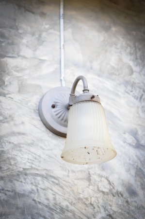 antique wall lamp on grungy cement wallの写真素材