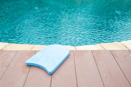 Blue foam board for the teaching of swimming beside swimming poolの写真素材