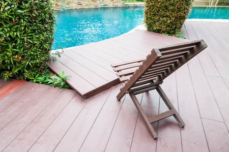 wooden chair beside swimming poolのeditorial素材