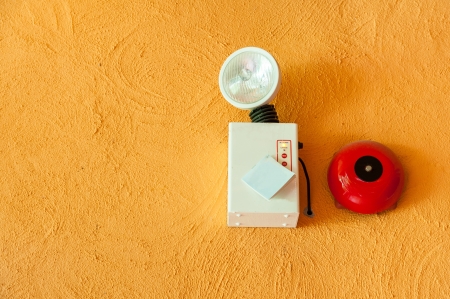 emergency lighting and fire alarm on orange wallの写真素材