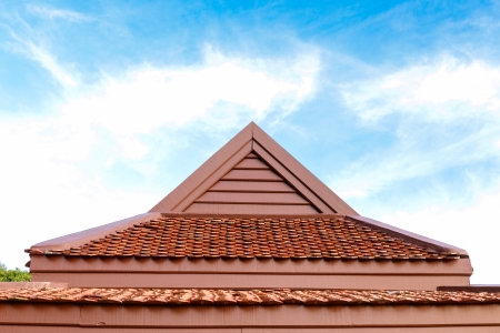  	 detail of wooden roof gable with clay roof tile on blue sky の写真素材