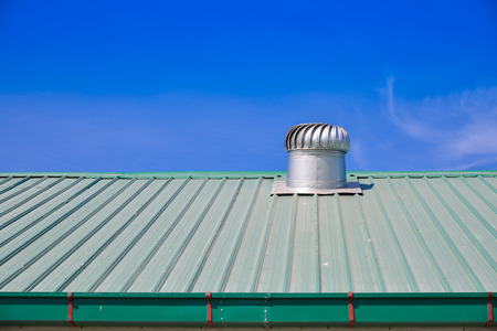 Turbine roof ventilation system on top of metal sheet roof の写真素材