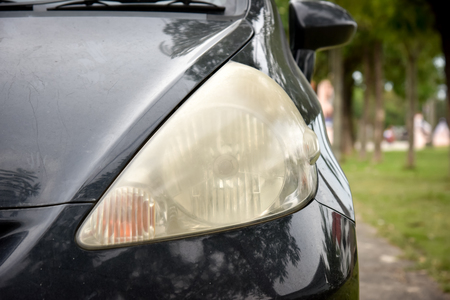 Damaged and blurred headlight surface as a result of weather condition and aging of a carの写真素材