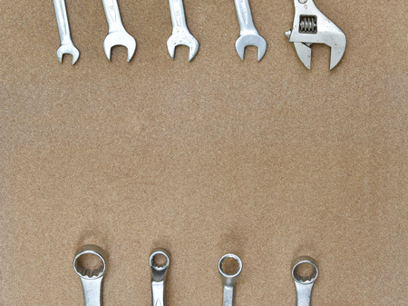 A forge and chrome vanadium material stamped on various wrench spanners tools lying on wood background with a copy space for textの写真素材